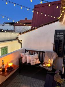 a bench on a balcony with lights and candles at Charming Casa Maria Pag in Pag