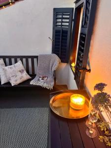 a table on a balcony with a bench and a candle at Charming Casa Maria Pag in Pag