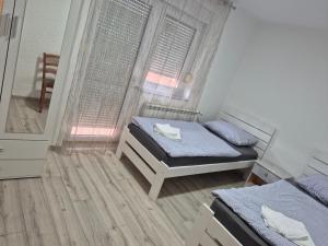 a small room with two beds and a window at Apartment LIKA in Gospić