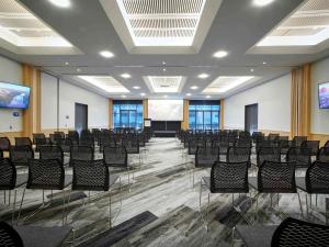 a conference room with chairs and a projector screen at Novotel Tainui Hamilton in Hamilton