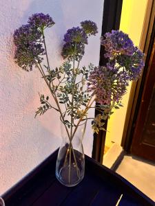 a glass vase filled with purple flowers on a table at Charming Casa Maria Pag in Pag