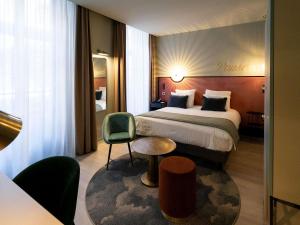 a hotel room with a bed and a chair at Hôtel Mercure Montauban in Montauban +88 photos