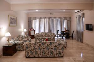 a living room with a couch and chairs and a table at Beach Luxury Hotel in Karachi