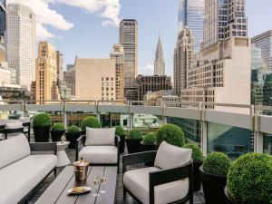 a rooftop patio with chairs and a view of a city at Sofitel New York in New York