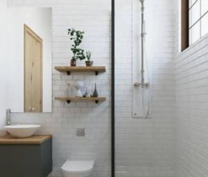 a bathroom with a shower with a toilet and a sink at Alfathpark in Nyomolong