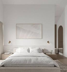 a white bedroom with a large bed and a painting at Alfathpark in Nyomolong