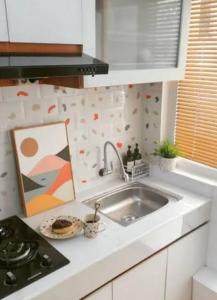 a kitchen counter with a sink and a painting at Alfathpark in Nyomolong