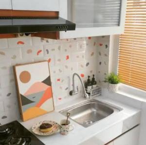 a kitchen with a sink and a painting on the counter at Alfathpark in Nyomolong
