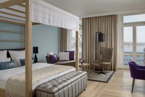 a bedroom with a bed and a desk and a chair at Steigenberger Inselhotel in Konstanz