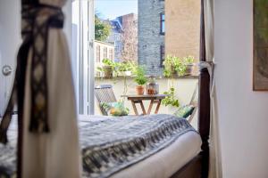 a bedroom with a bed and a balcony with a table at 66 Guldsmeden in Copenhagen