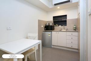 a kitchen with white cabinets and a sink at Surf Beach Motel Port in Port Macquarie