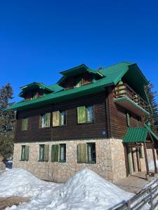 a large building with snow in front of it at Dormire Apartmans in Žabljak
