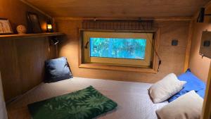 a small room with a window and a bed and a chair at Pirts Rozēni in Saulkrasti