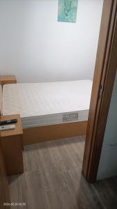 a bed in a room next to a door at Casa Bisavós de Coelhosa in Vale de Cambra