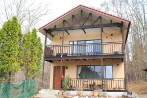 a house with a balcony on top of it at ヴィラルミエール in Yamanakako