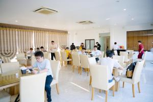 a group of people sitting at tables in a restaurant at TỪ SƠN LUXURY 2 HOTEL in Ðại Dính