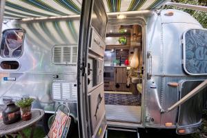 an open door of a silver trailer with a table at 66 Guldsmeden in Copenhagen
