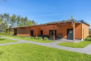 a wooden building with a porch and a patio at Ferienhäuser im Sternenpark am See in Lochow