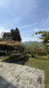 a picnic table and an umbrella on a patio at Casa Flavia in Lierna