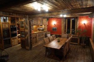 a kitchen with a wooden table and chairs at Maison d'hôtes La Barmaz in Combloux