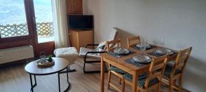 a dining room with a table and chairs and a television at Studio Bellevue Veysonnaz in Veysonnaz