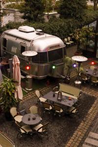 an rv parked with tables and chairs in front of it at 66 Guldsmeden in Copenhagen