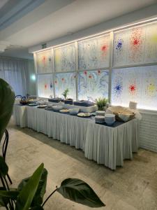 a banquet hall with white tables with dishes on them at Hotel Arabesco in Rimini +39 photos