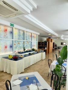 a banquet hall with tables and chairs in a room at Hotel Arabesco in Rimini