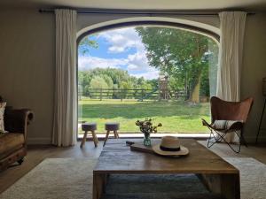 a living room with a large window and a table at Muntershof in Zottegem