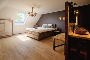a bedroom with a large bed and a window at Muntershof in Zottegem