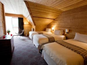a row of four beds in a room with wooden walls at Mercure Saint-Lary in Saint-Lary-Soulan +209 photos