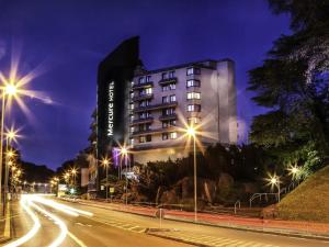 a building on a city street at night at Mercure Hotel Hagen in Hagen