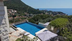 a swimming pool with chairs and umbrellas on a building at Villa Verra in Pržno