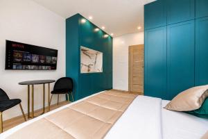 a bedroom with a bed and a blue wall at GreenRoom Kunigiškės in Palanga