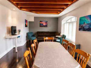 a room with a table and chairs and a couch at Aran View Holiday Homes Doolin - The Courtyard House - Sleeps 9 in Knockfin Cross Roads