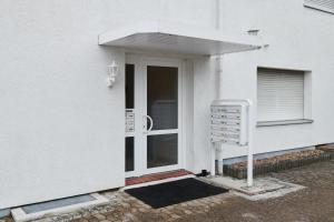 a front door of a white house with an awning at Gemütliche Appartement in Bad Oeynhausen