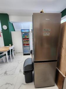 a refrigerator in a store with a trash can and a table at The HANGOUT Hostel in Sarandë