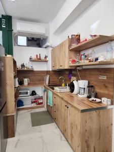 a large kitchen with wooden cabinets and appliances at The HANGOUT Hostel in Sarandë