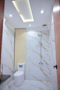 a white bathroom with a toilet and a mirror at Hotel Taj Palace in Sialkot +72 photos