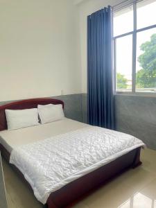 a bedroom with a large bed with a window at khách sạn Mya in Ấp An Hòa (2)