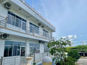 a white building with windows and a balcony at khách sạn Mya in Ấp An Hòa (2)