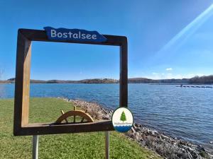 a sign in front of a body of water at Waldzauber Retreat in Nohfelden