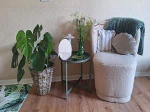 a living room with a chair and a table with flowers at Waldzauber Retreat in Nohfelden