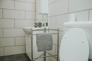 a white bathroom with a sink and a towel at Studio Pod hruško in Kobarid +6 photos