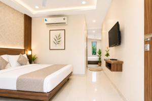 a bedroom with a bed and a flat screen tv at Strand Resort in Lonavala