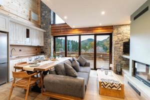 a kitchen and living room with a couch and a table at Monte Verde Resort Kalavrita in Kalavrita