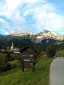 a sign on the side of a road with mountains in the background at Studio Pod hruško in Kobarid