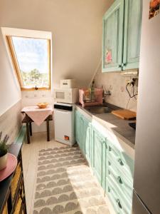 a kitchen with green cabinets and a sink and a window at Penzión U Koníka in Liptovský Ján