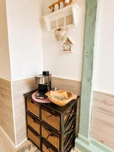 a bathroom with a sink and a coffee maker on a table at Penzión U Koníka in Liptovský Ján