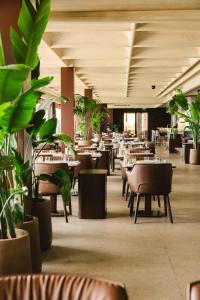 a restaurant with tables and chairs and potted plants at Divan Mersin in Mersin